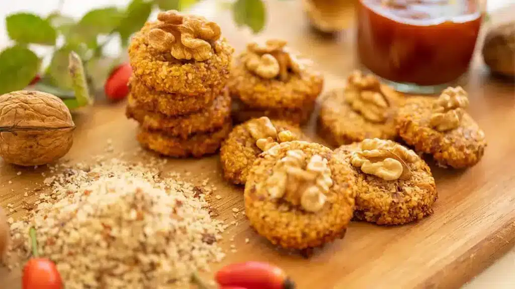 Hagebuttenplätzchen mit Walnüssen auf Holzbrett – natürliche Winterkekse aus heimischen Zutaten