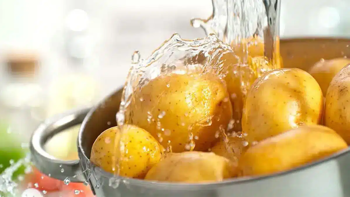Frisch gekochte Kartoffeln werden mit kaltem Wasser abgeschreckt, um sie abkühlen zu lassen.