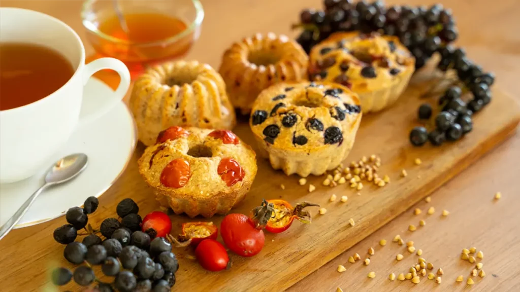 Herbstliche Muffins mit Hagebutten und Wildbeeren auf einem Holztisch – gesunde Leckerei im Oktober