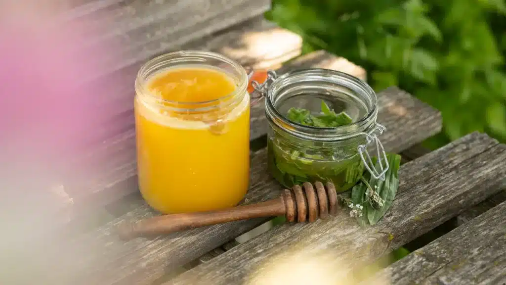 Frisch zubereitetes Oxymel im Glas mit Honig und Kräutern – traditionelles Kräuterelixier im September