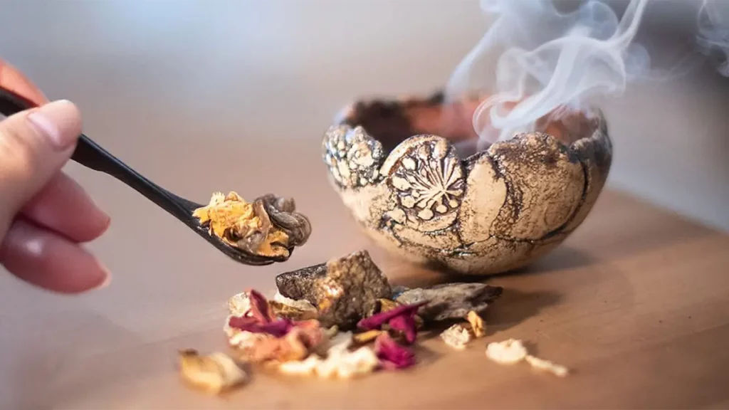 Räucherschale mit glühender Kohle, Harzen und Kräutern beim Räuchern im Dezember
